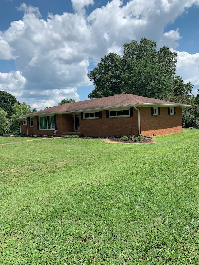 single story home featuring brick siding and a front lawn