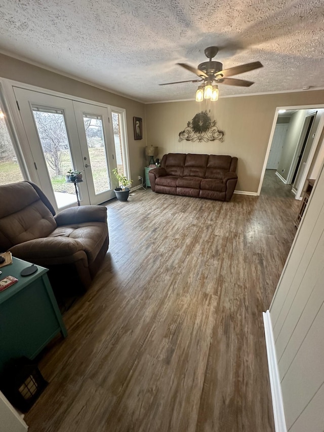 living area with a textured ceiling, ceiling fan, french doors, and dark wood finished floors