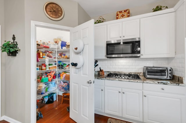 kitchen featuring appliances with stainless steel finishes, white cabinetry, and a toaster