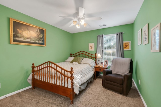 carpeted bedroom with visible vents, baseboards, and a ceiling fan