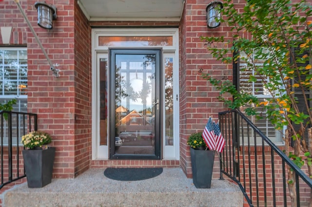 entrance to property featuring brick siding