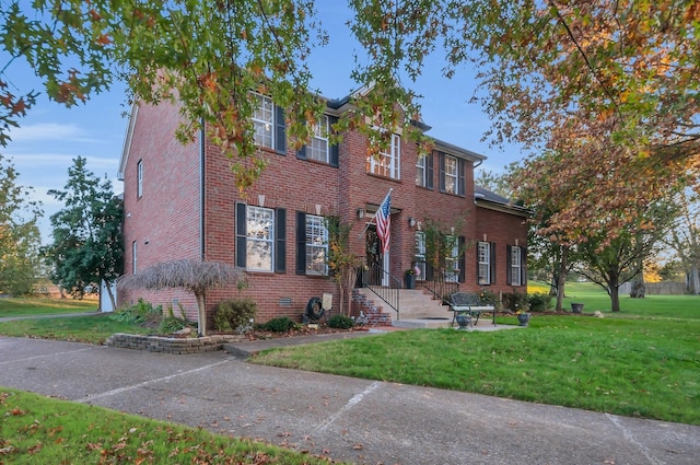 view of front facade with a front yard, crawl space, and brick siding