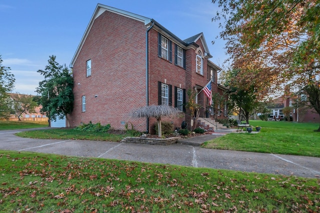 view of side of home featuring a yard and brick siding