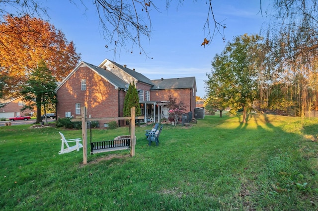 rear view of property with a lawn and brick siding