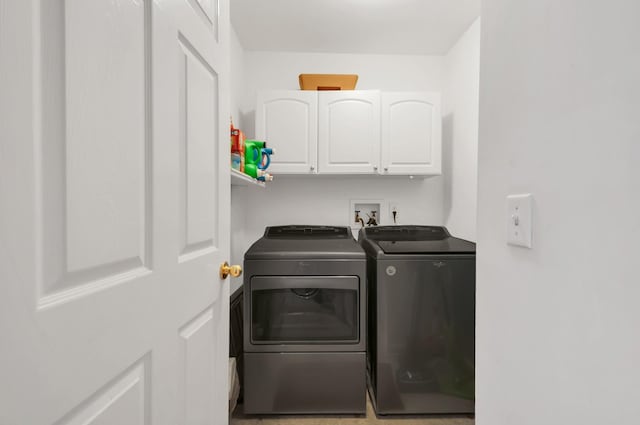 clothes washing area with washer and clothes dryer and cabinet space