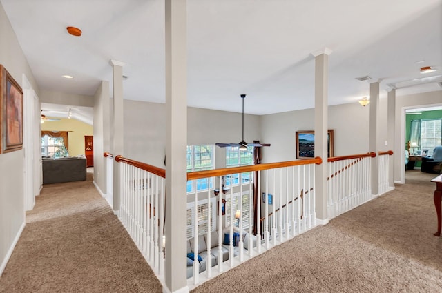 hall with carpet floors, visible vents, and baseboards