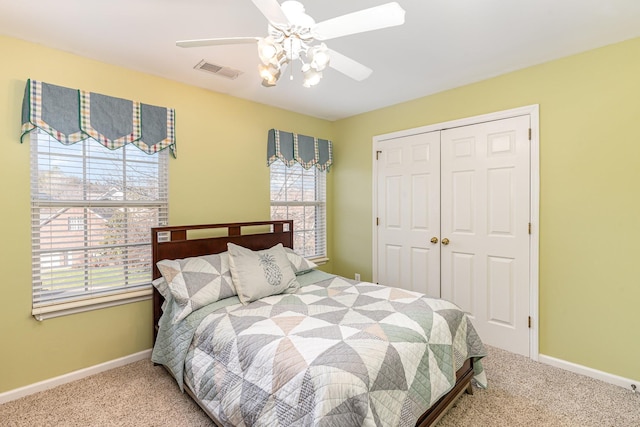 carpeted bedroom with a closet, visible vents, ceiling fan, and baseboards