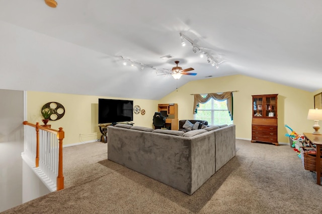 carpeted living room featuring track lighting, lofted ceiling, visible vents, and baseboards