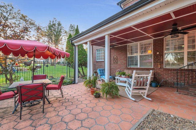 view of patio with a ceiling fan, outdoor dining area, and fence