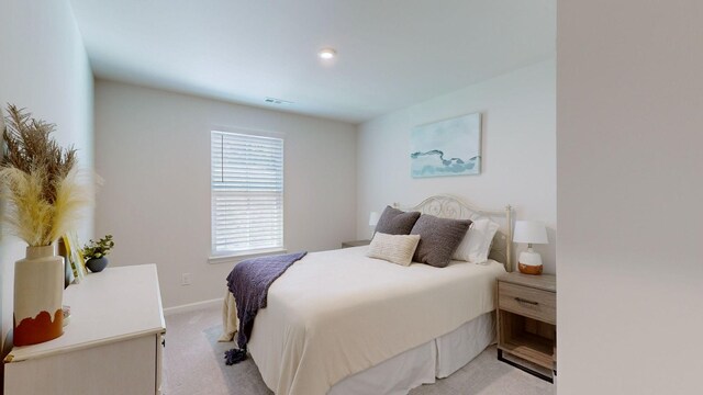 bedroom with light carpet, visible vents, and baseboards