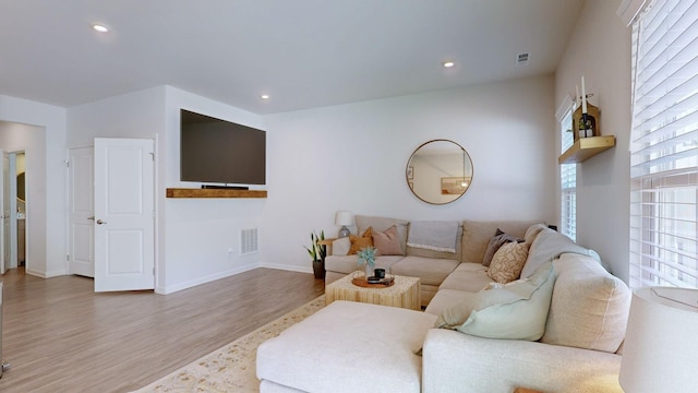 living area with recessed lighting, visible vents, baseboards, and wood finished floors