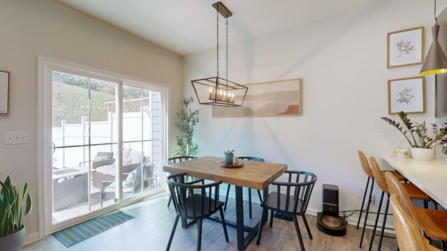 dining area with an inviting chandelier, baseboards, and wood finished floors