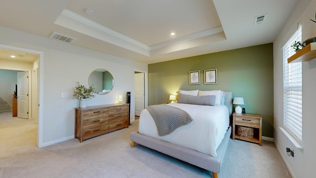 bedroom with visible vents, a tray ceiling, and light colored carpet