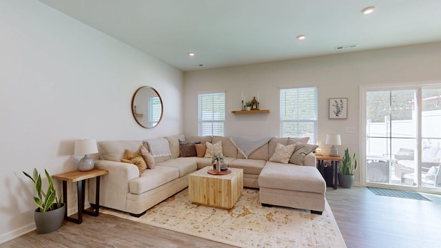 living area with baseboards, visible vents, wood finished floors, and recessed lighting