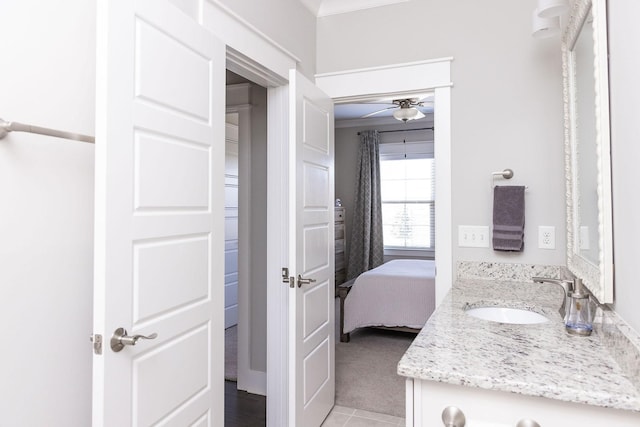 bathroom featuring ornamental molding, ceiling fan, vanity, and ensuite bathroom