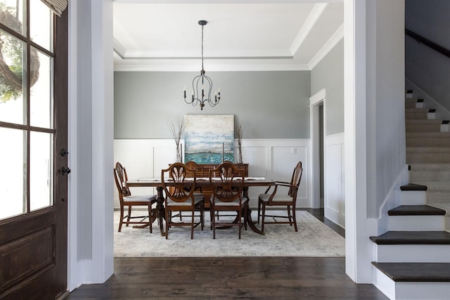 dining space featuring ornamental molding, dark wood finished floors, and stairs