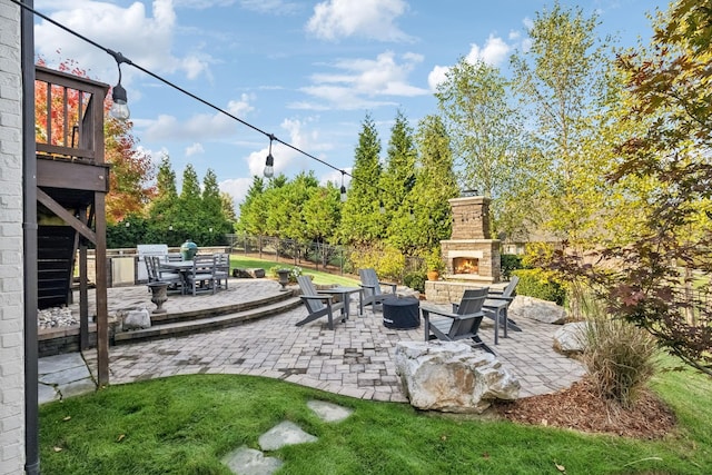 view of patio with fence, an outdoor stone fireplace, and outdoor dining area