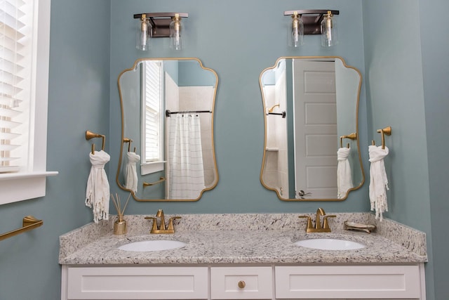 full bathroom with a sink, a shower with shower curtain, and double vanity