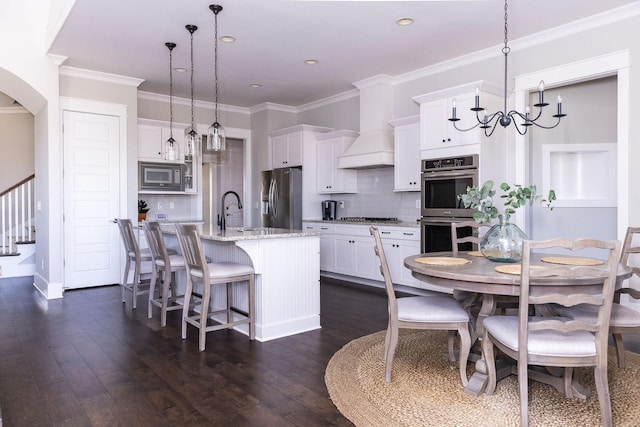 kitchen with custom exhaust hood, backsplash, appliances with stainless steel finishes, dark wood-type flooring, and white cabinets