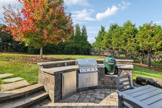 view of patio featuring exterior kitchen, a fenced backyard, and grilling area