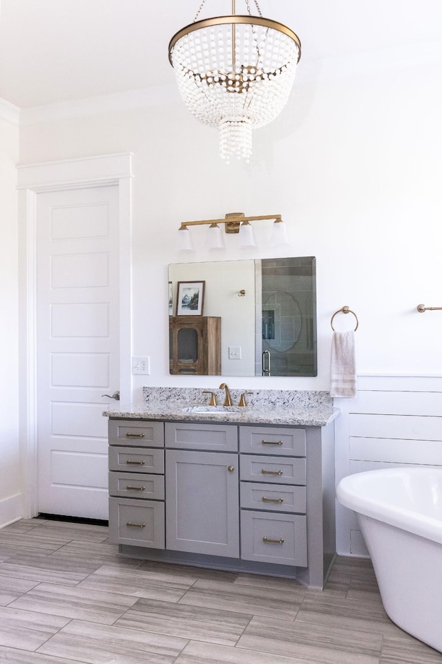 bathroom with an inviting chandelier, an enclosed shower, a freestanding bath, and vanity