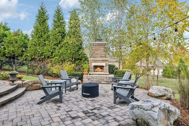 view of patio / terrace with an outdoor stone fireplace and fence