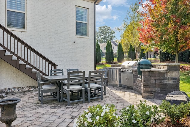 view of patio featuring a grill, stairs, fence, and outdoor dining area