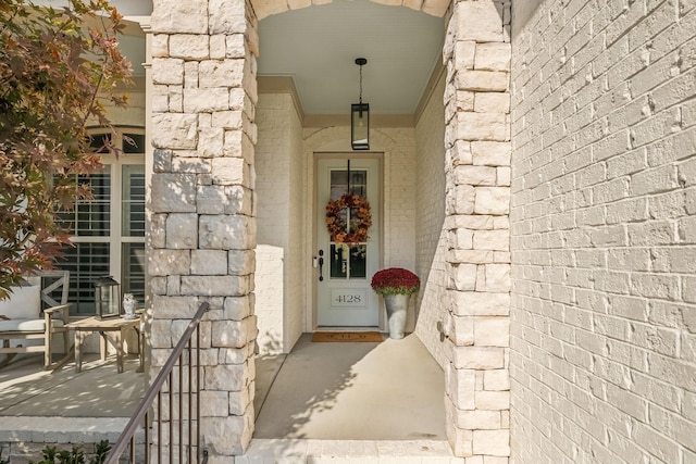 doorway to property with stone siding and brick siding