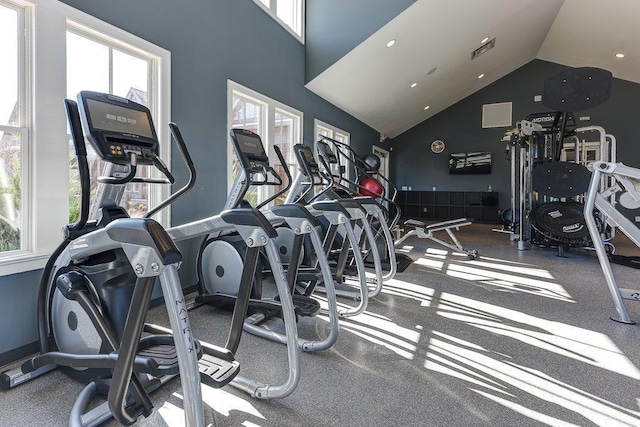 exercise room with a healthy amount of sunlight, vaulted ceiling, and visible vents