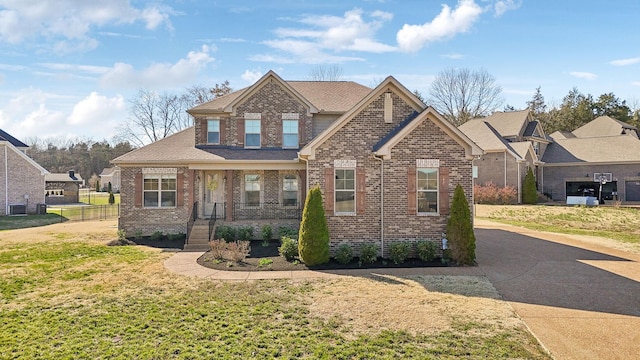 craftsman house with brick siding, a front yard, and fence