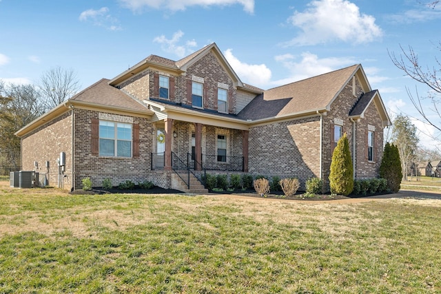 view of front of home featuring brick siding, covered porch, and a front yard