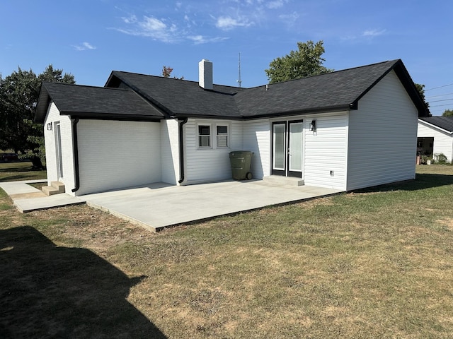 rear view of house featuring a chimney, roof with shingles, a yard, a patio area, and brick siding