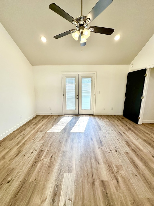 empty room with a ceiling fan, baseboards, vaulted ceiling, light wood-style floors, and french doors