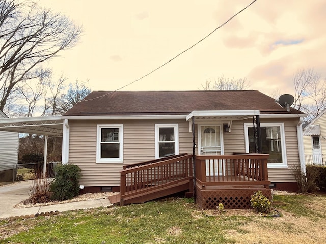 bungalow-style house with roof with shingles, concrete driveway, crawl space, an attached carport, and a front lawn