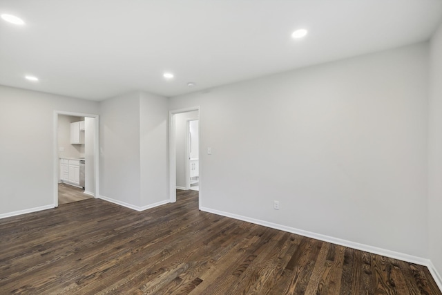 empty room featuring recessed lighting, dark wood finished floors, and baseboards