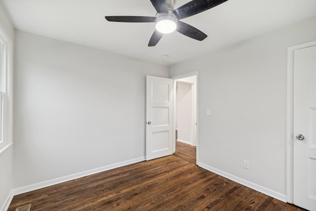 unfurnished bedroom featuring a ceiling fan, baseboards, and dark wood-style flooring