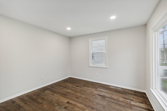 unfurnished room with dark wood-style floors, recessed lighting, visible vents, and baseboards