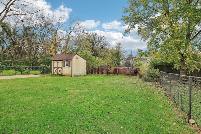 view of yard featuring a shed, an outdoor structure, and a fenced backyard