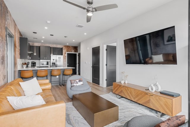 living area with recessed lighting, light wood-type flooring, and ceiling fan