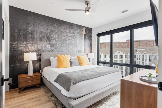 bedroom with visible vents, light wood-style flooring, and ceiling fan