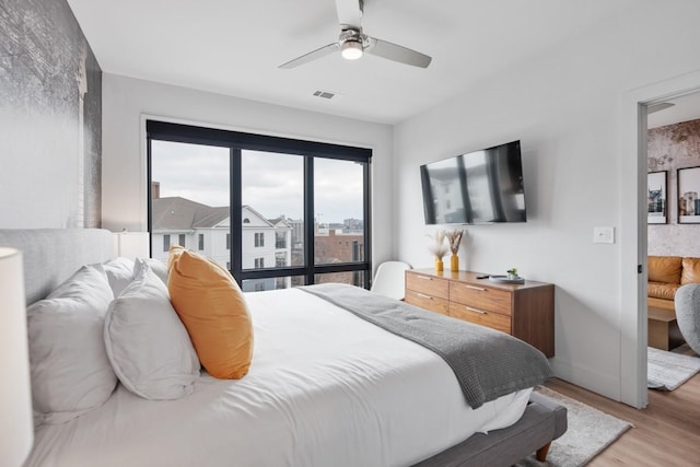 bedroom with visible vents, baseboards, light wood-type flooring, and ceiling fan