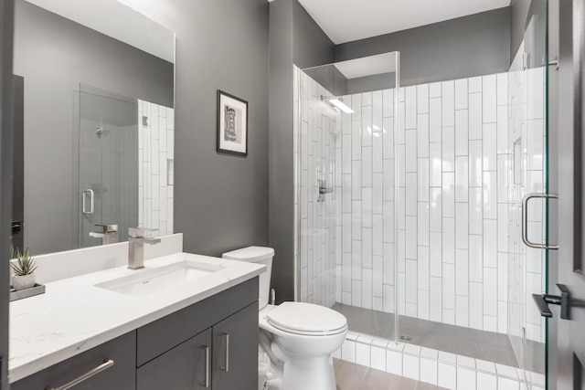 full bathroom with vanity, a shower stall, and toilet