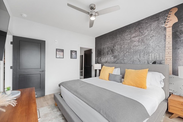 bedroom with ceiling fan, baseboards, and wood finished floors