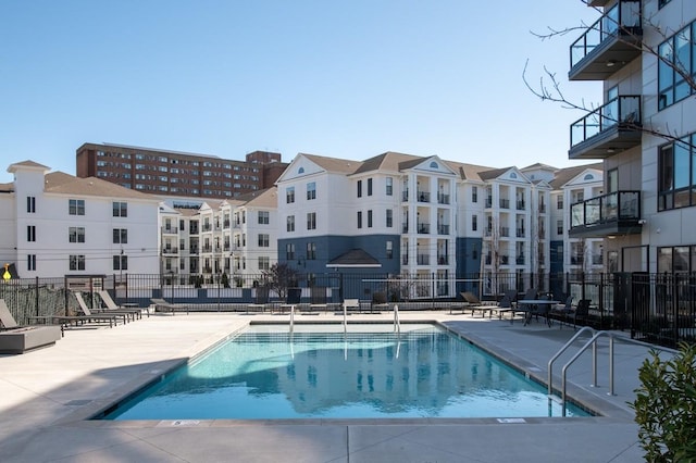 community pool with a patio and fence