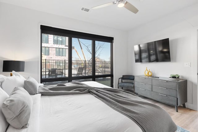 bedroom featuring a ceiling fan, light wood-type flooring, visible vents, and access to exterior