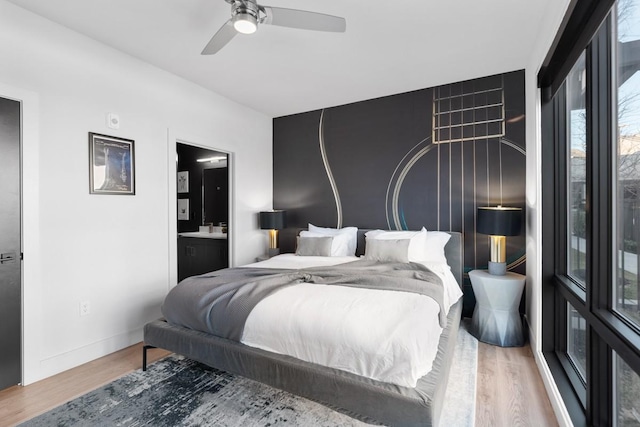 bedroom featuring ceiling fan, connected bathroom, baseboards, and wood finished floors