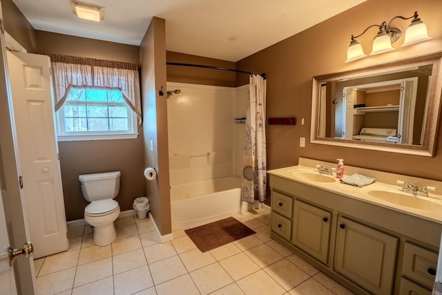 full bathroom with double vanity, a sink, toilet, and tile patterned floors