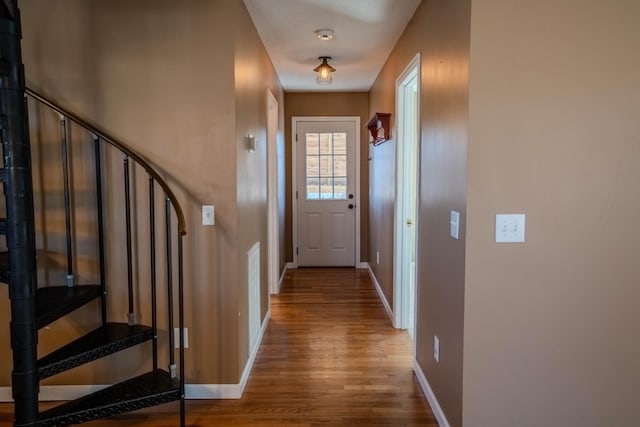 doorway to outside with stairs, wood finished floors, and baseboards