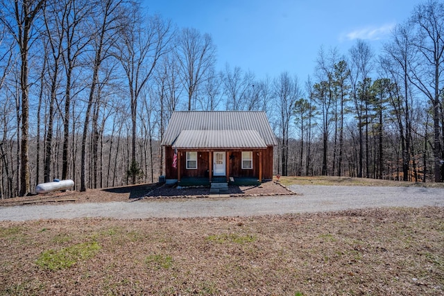 view of front of home featuring metal roof and a view of trees