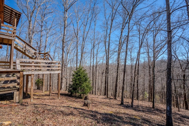 view of yard featuring a forest view and stairway